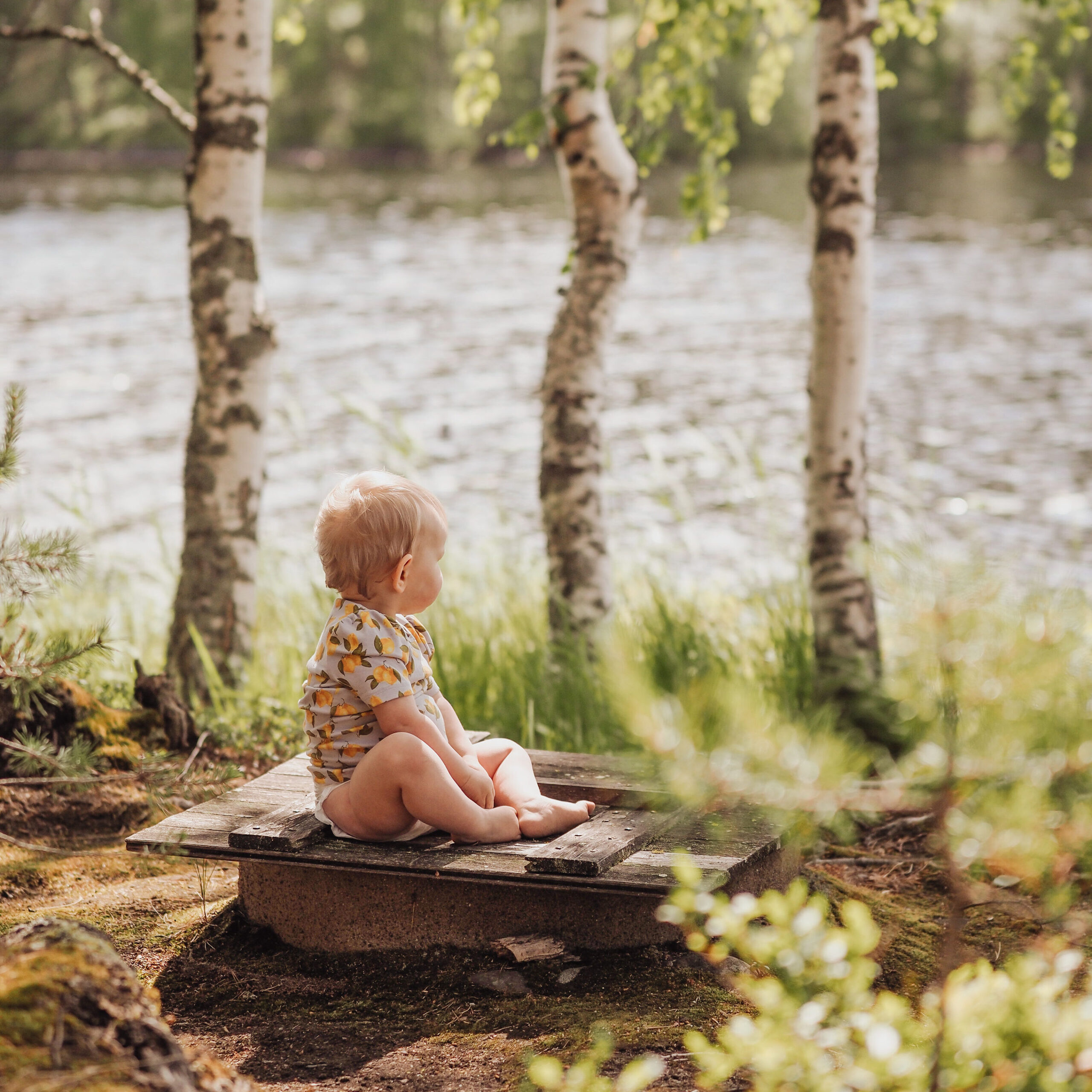 Lapsi istuu kiven päällä kotimaiset Moomin Baby -vaipat jalassa